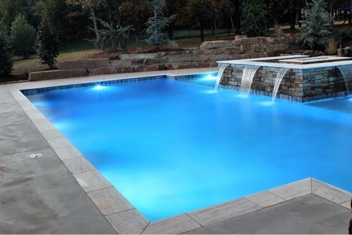 A large swimming pool with a waterfall in the middle