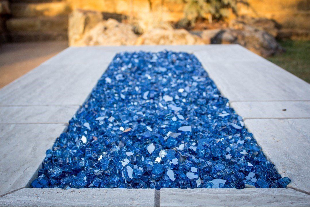 A pile of blue glass is sitting on top of a concrete surface.