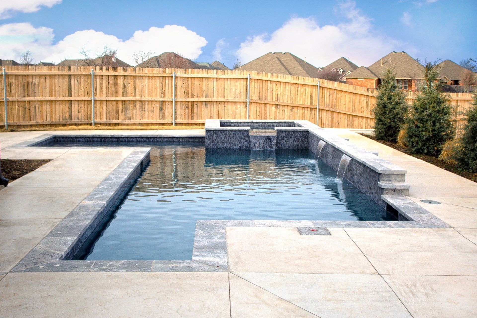 A large swimming pool with a wooden fence surrounding it