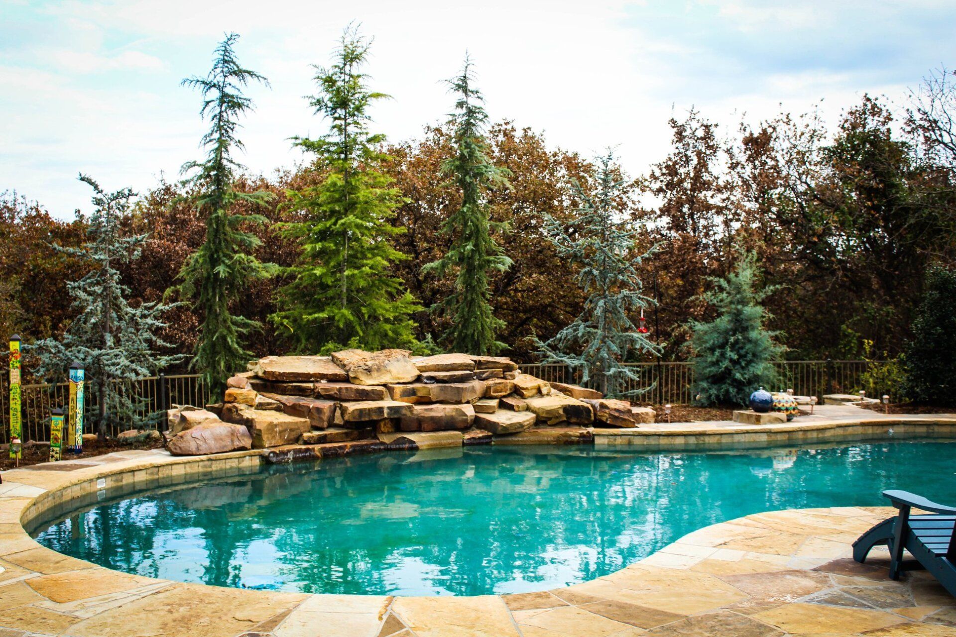 A large swimming pool surrounded by trees and rocks