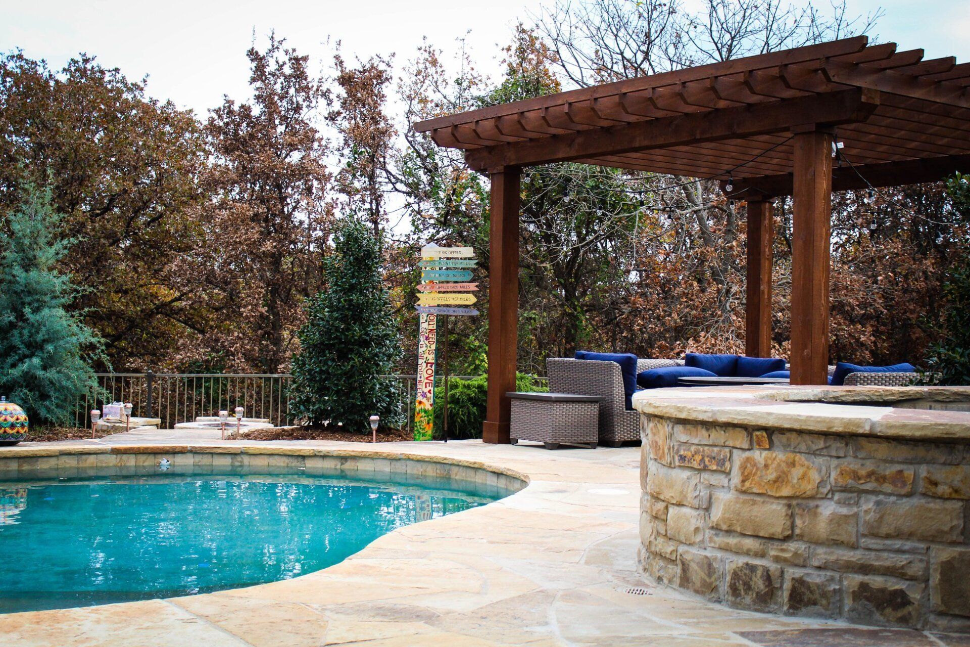 A large swimming pool with a wooden pergola over it