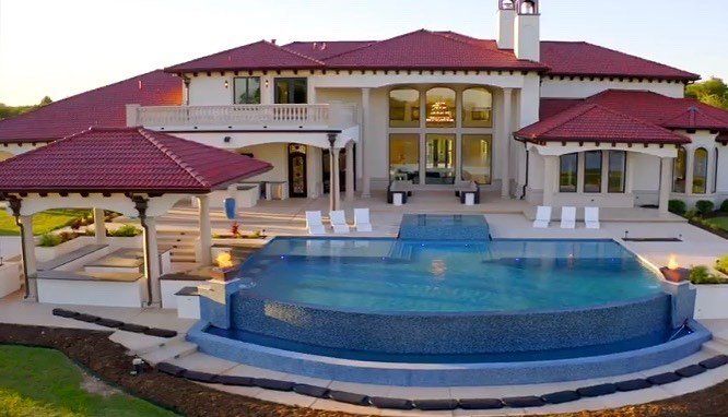 A large house with a large swimming pool in front of it