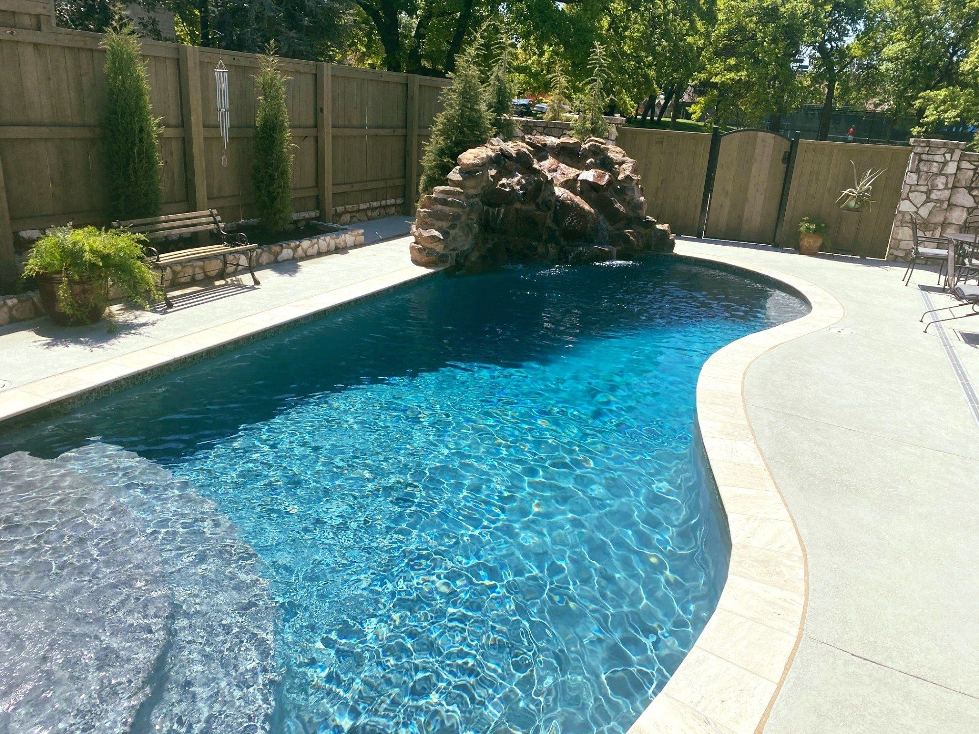 A large swimming pool with a waterfall in the middle of it.