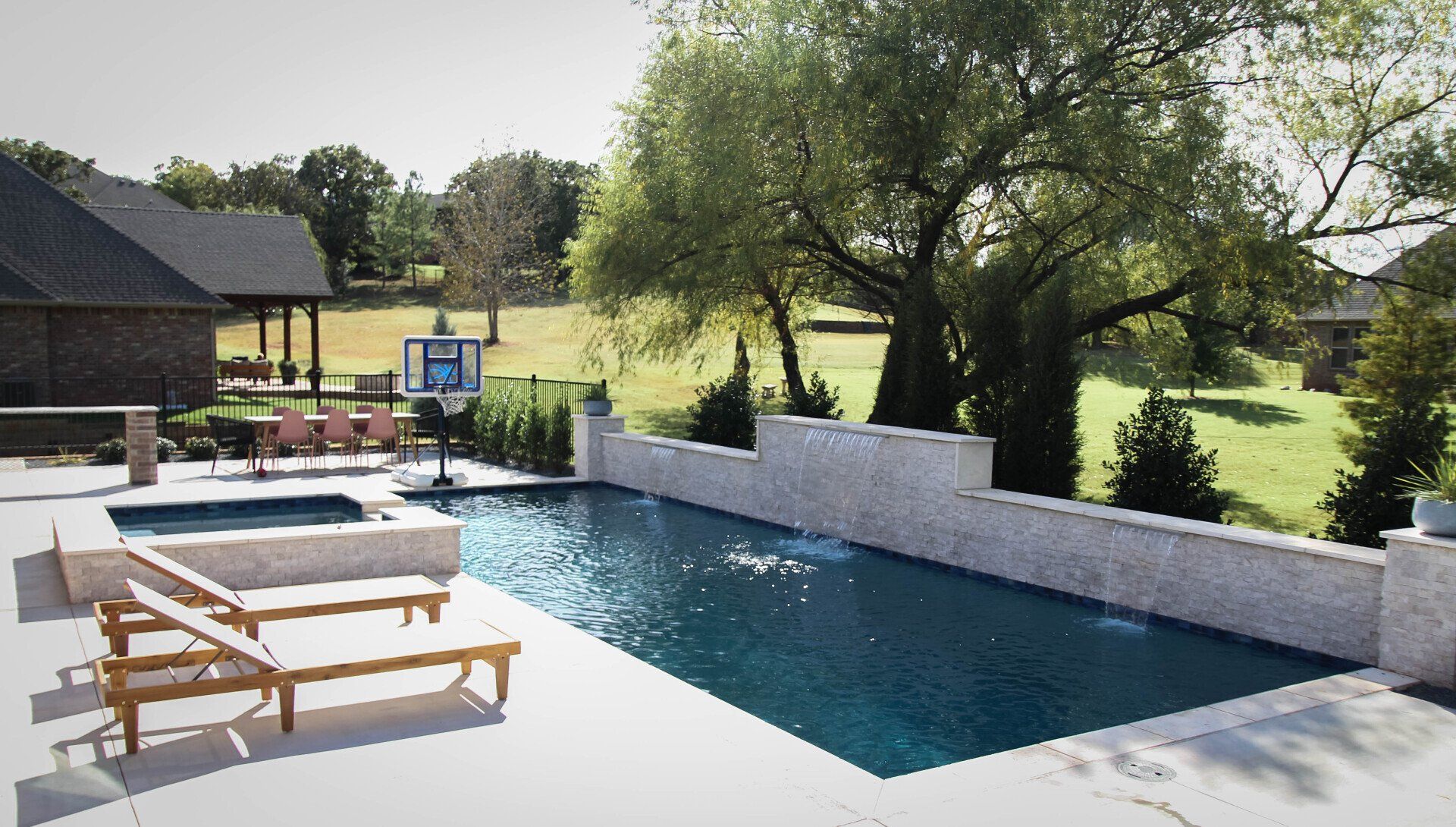A large swimming pool surrounded by lawn chairs and a house