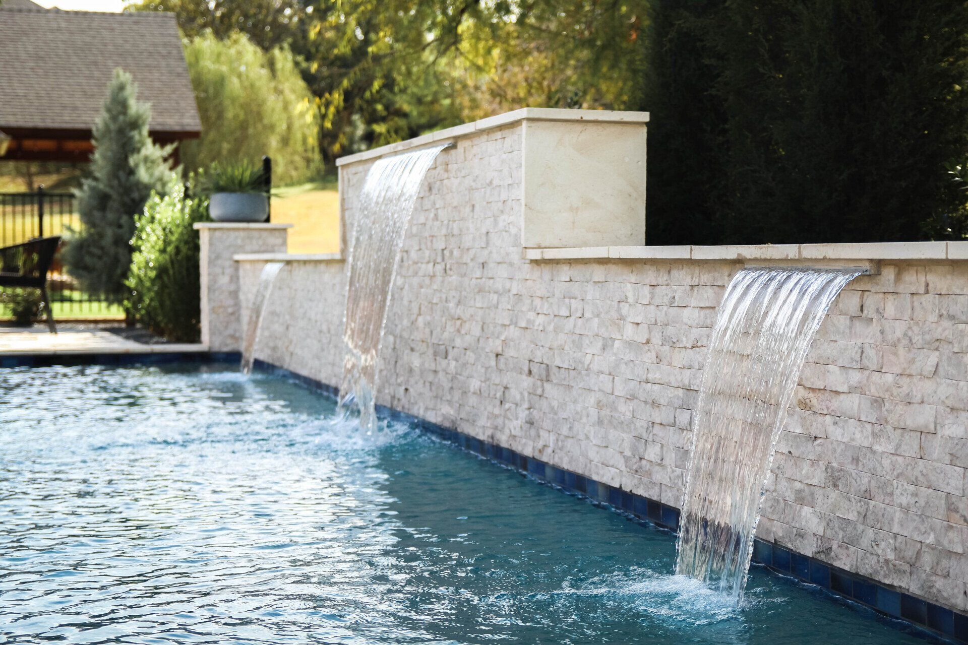 A swimming pool with a waterfall on the side of it