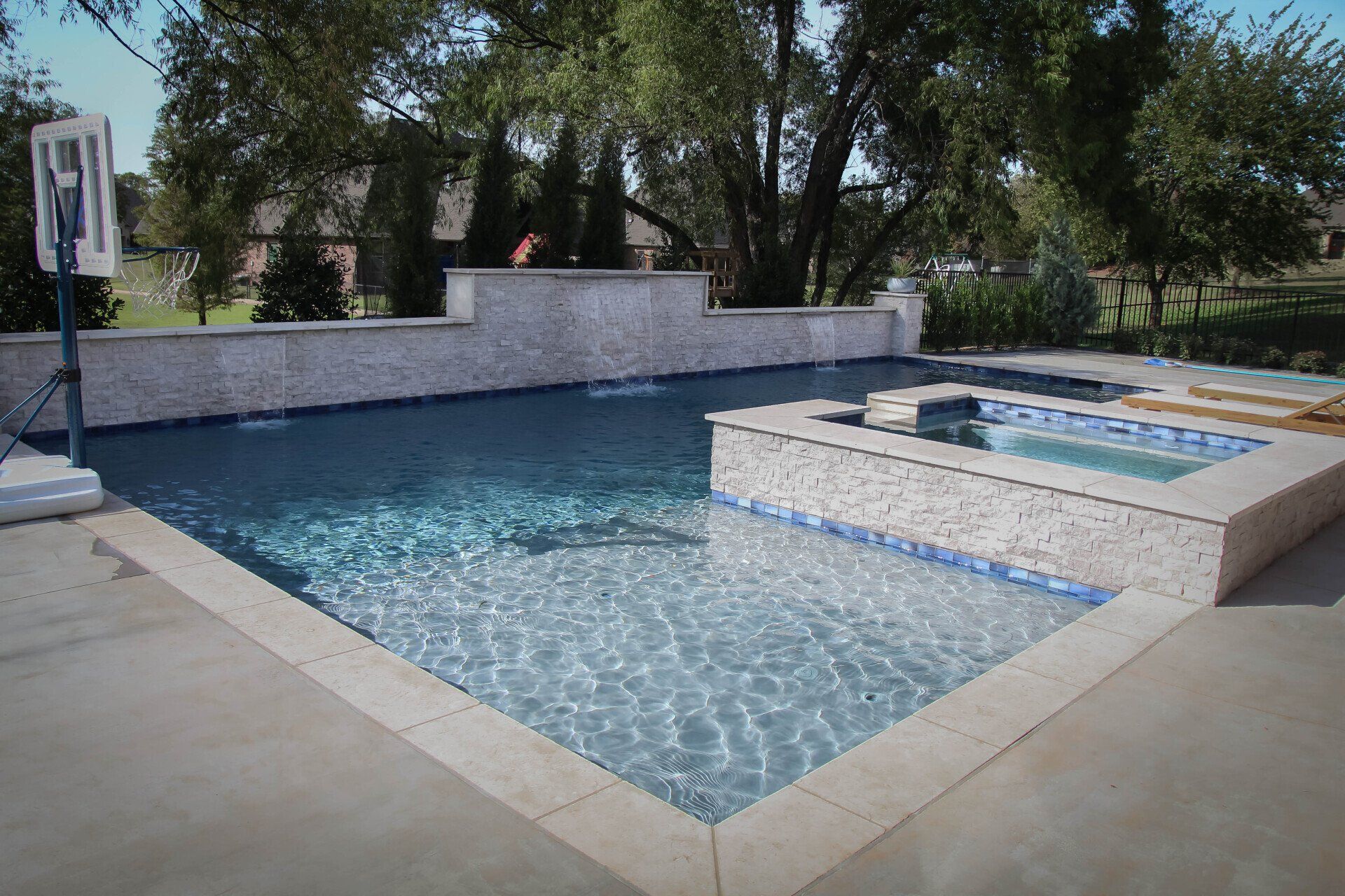 A large swimming pool with a basketball hoop in the background