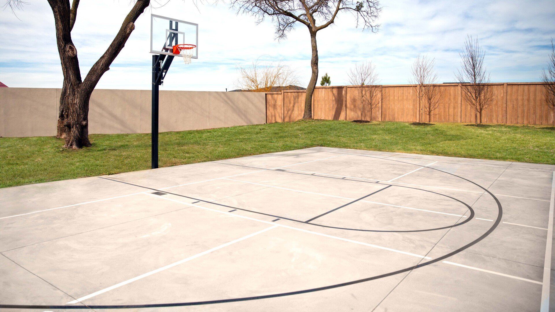 A basketball court with a tree in the background