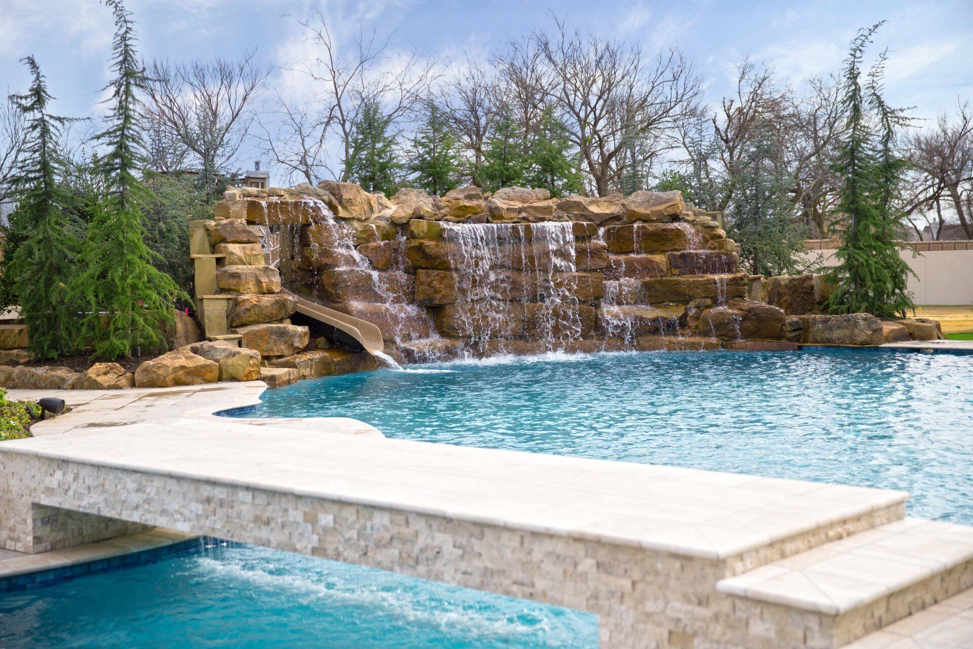 A large swimming pool with a waterfall in the background.