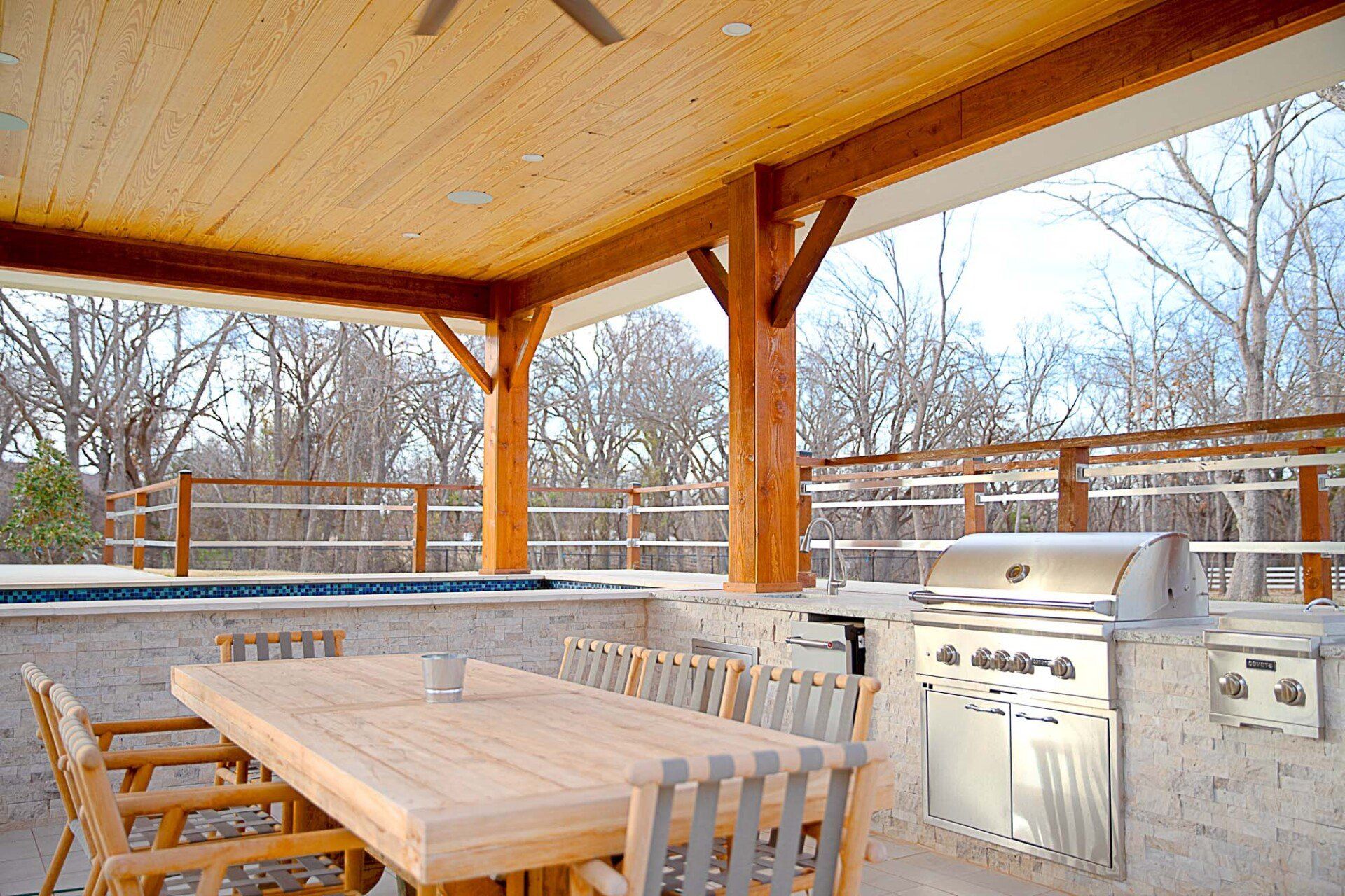 A patio with a table and chairs and a grill