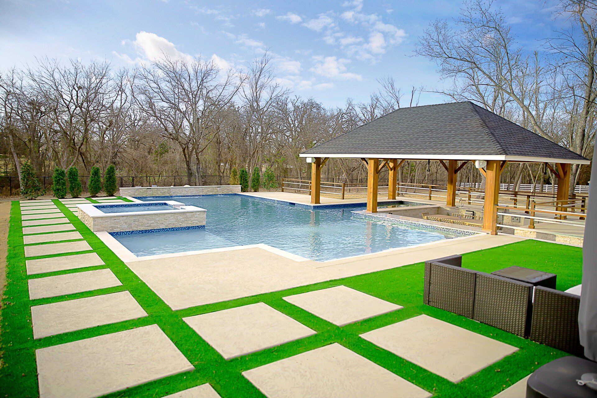 There is a large swimming pool in the backyard with a gazebo.