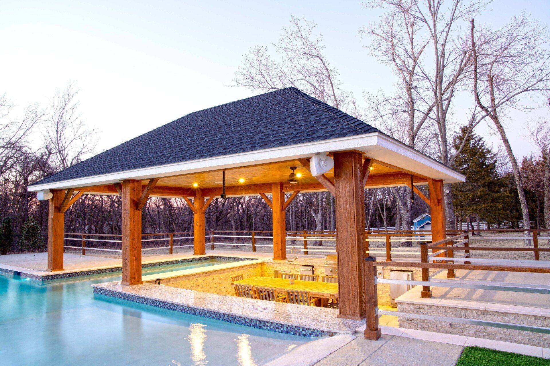There is a gazebo overlooking a swimming pool.