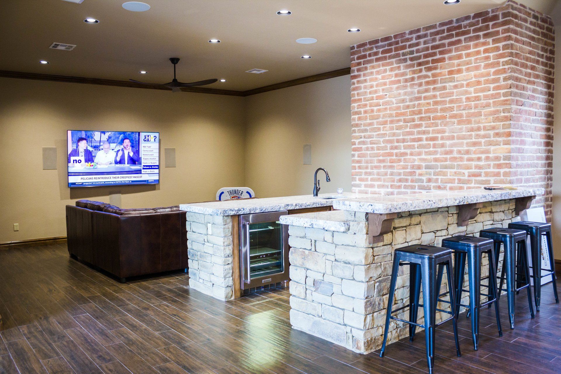 A living room with a bar and a television on the wall.