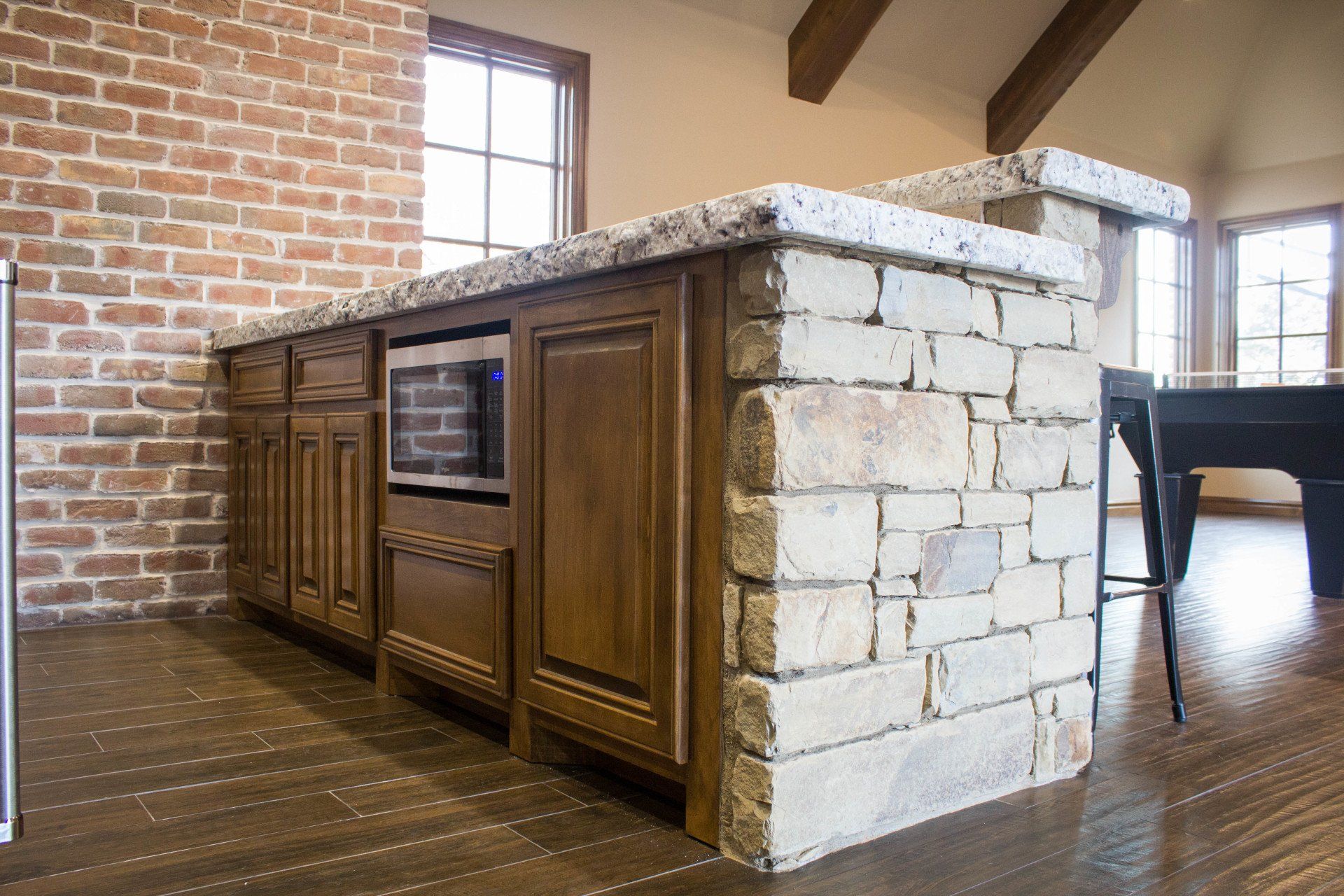 A kitchen with a large island and a brick wall