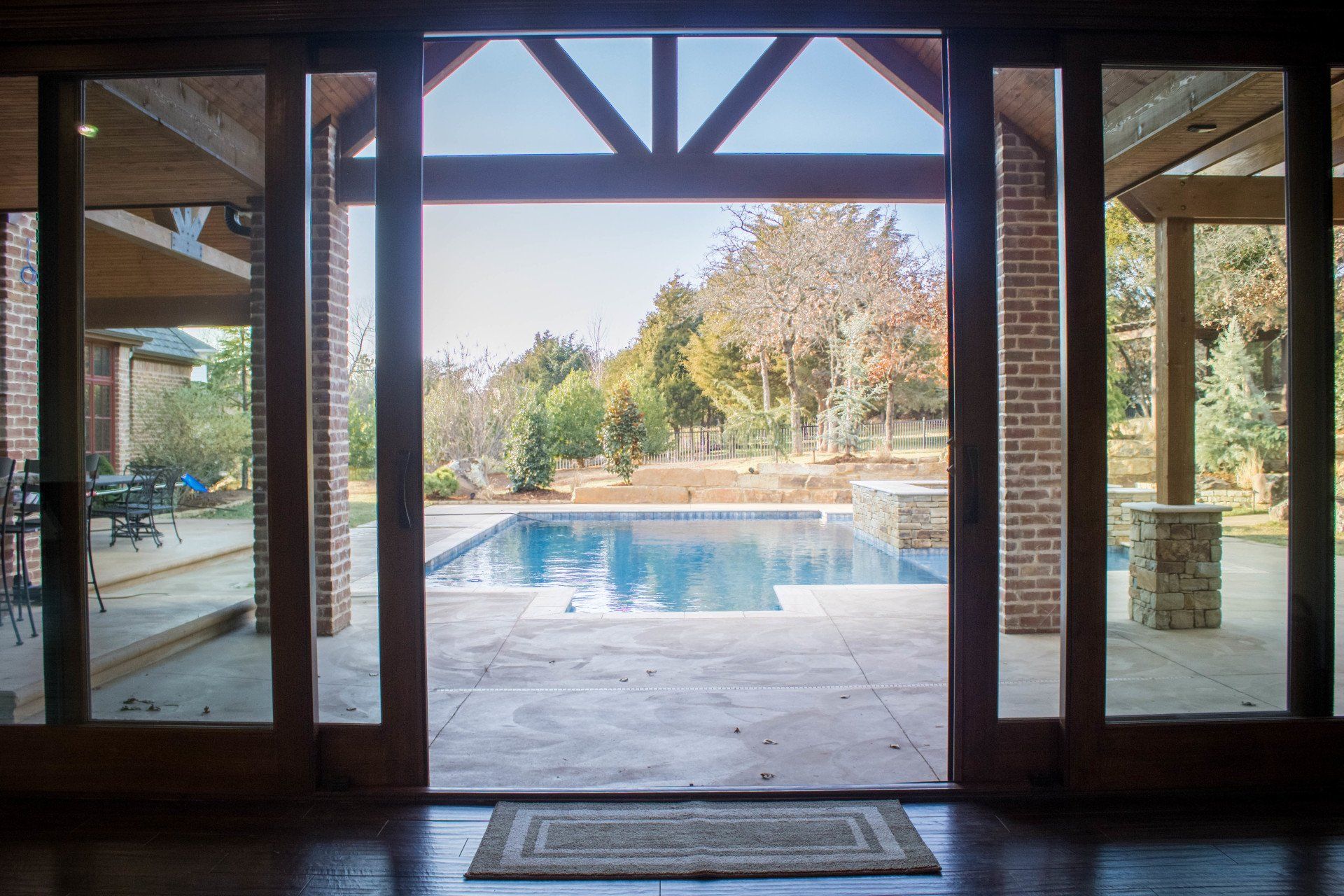 A view of a swimming pool through a sliding glass door.