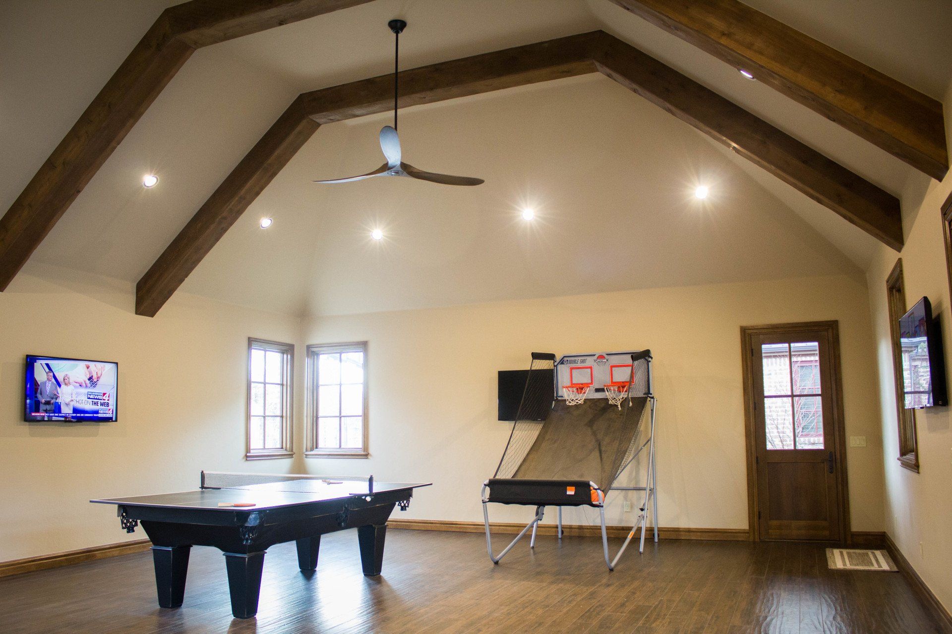 A game room with a pool table and a basketball hoop