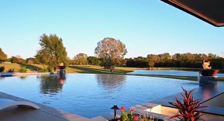 A large swimming pool with a view of a golf course.