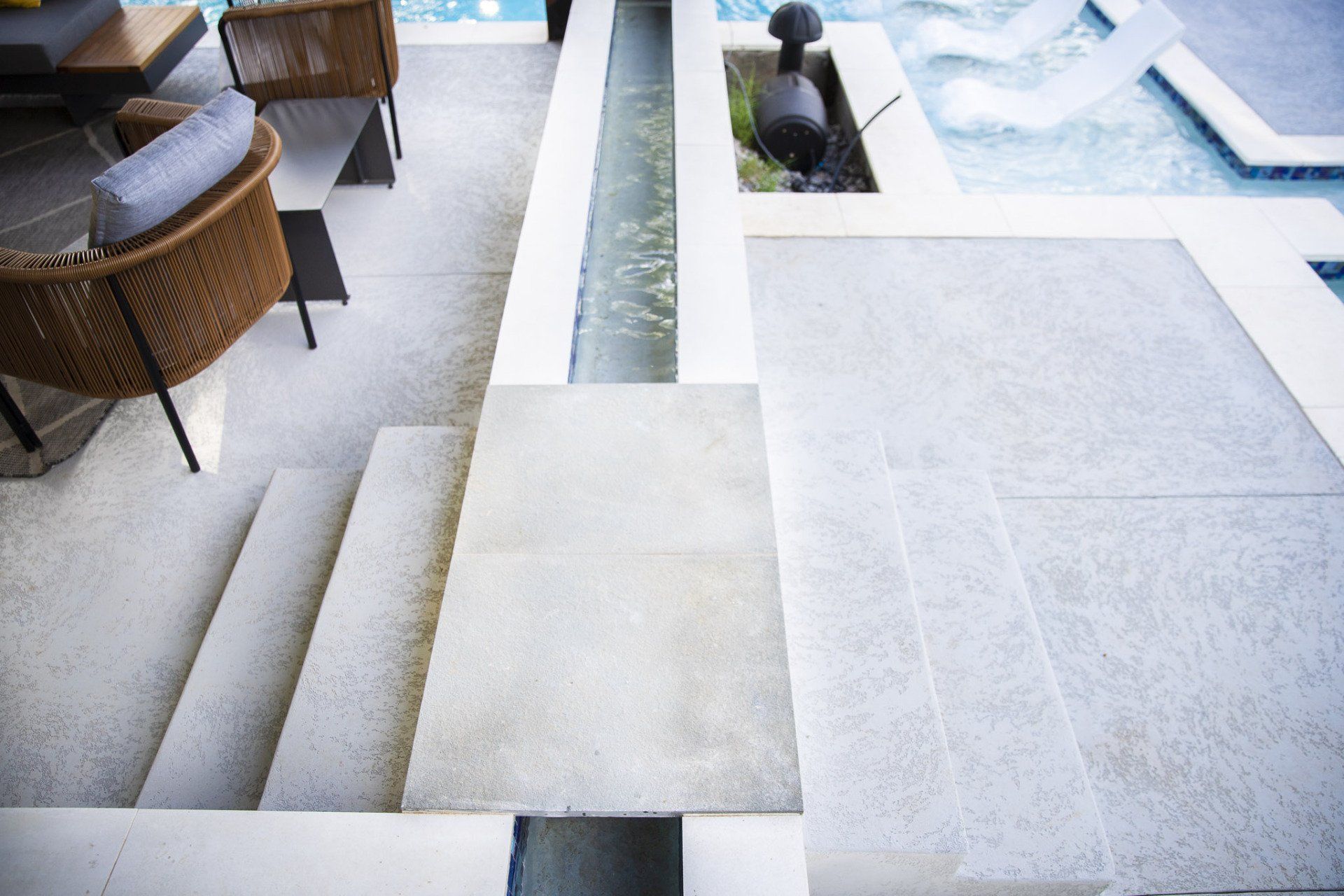 A staircase leading to a pool with a fountain in the middle