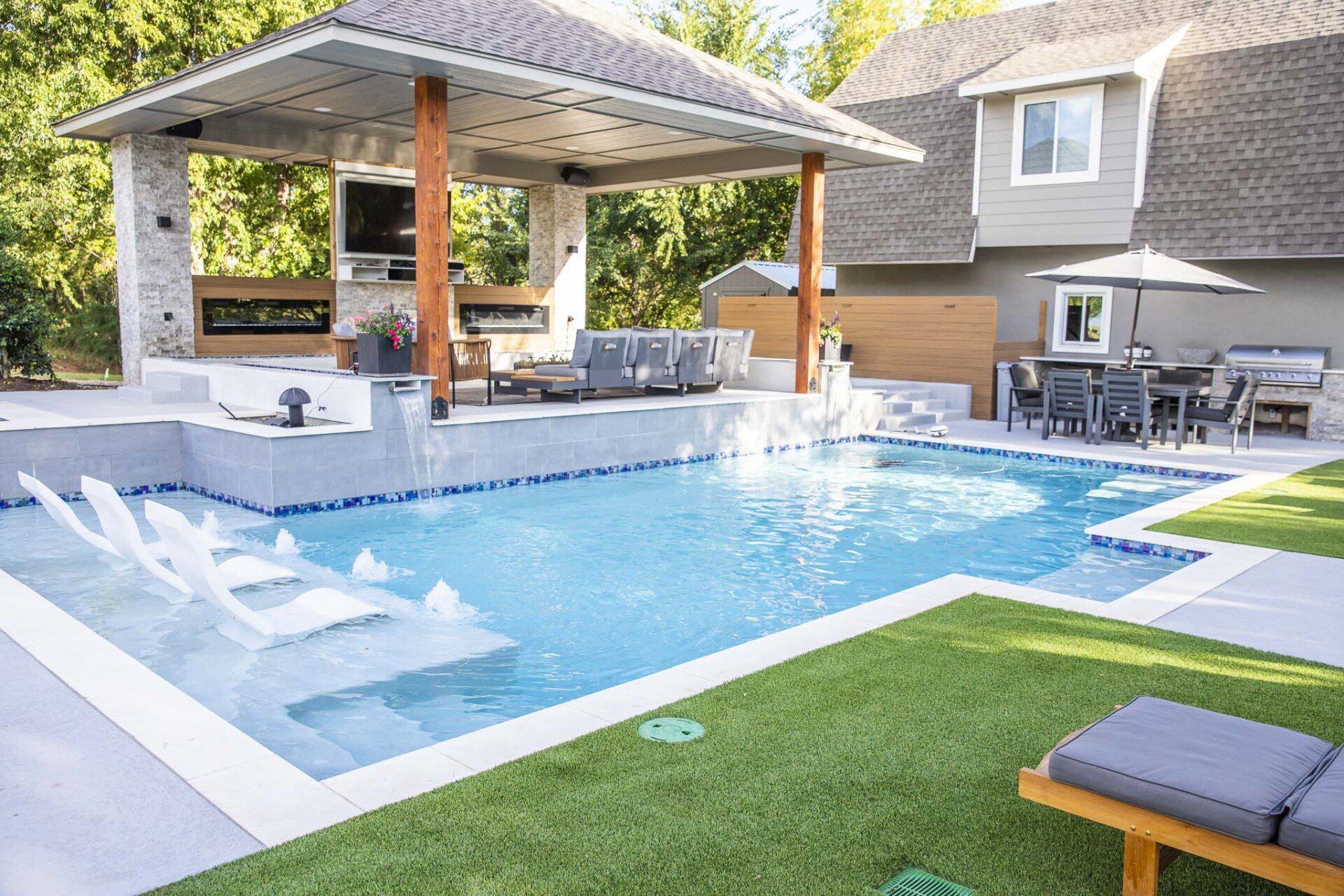 There is a large swimming pool in the backyard of a house.