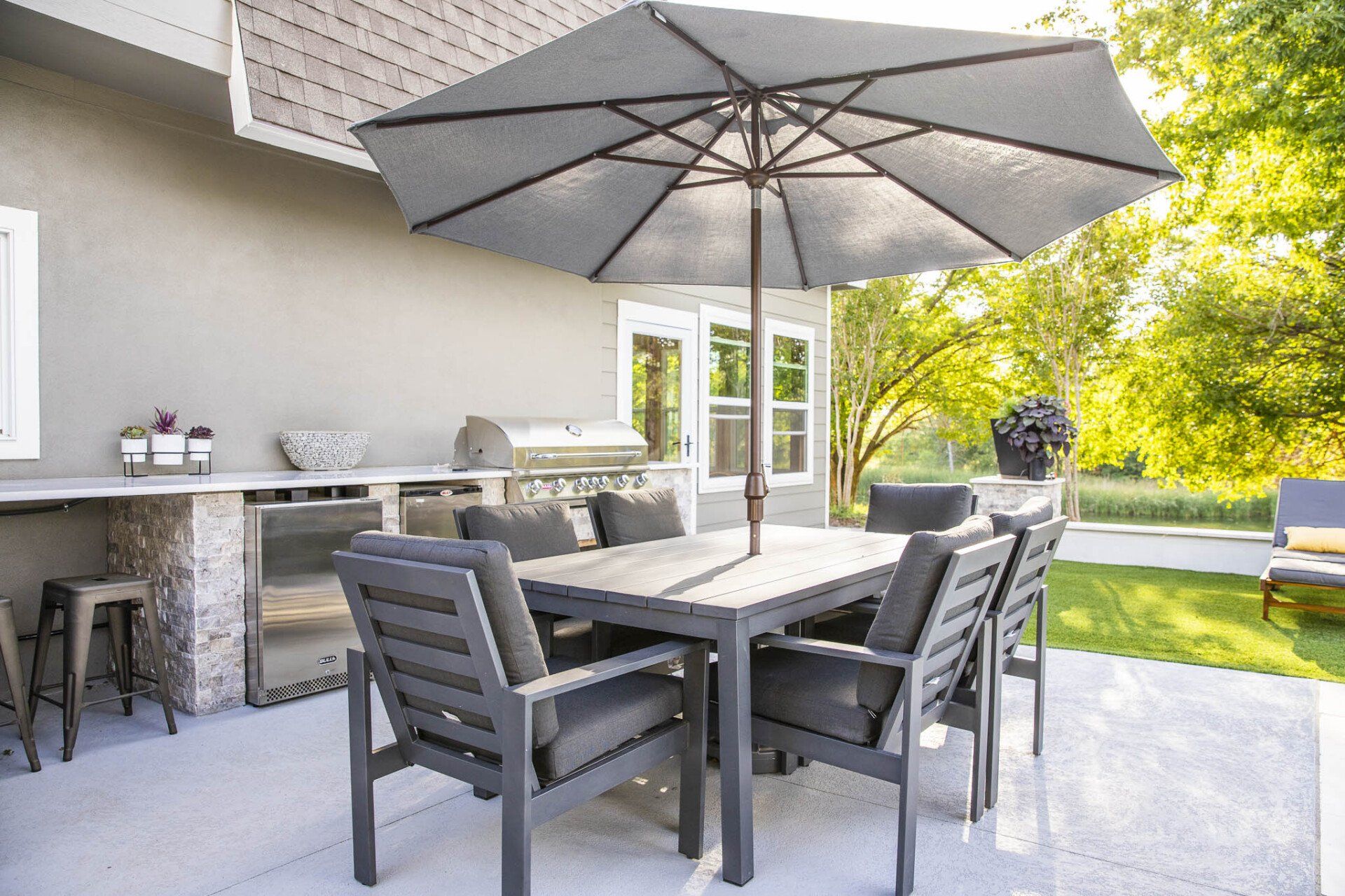 A patio with a table and chairs under an umbrella.