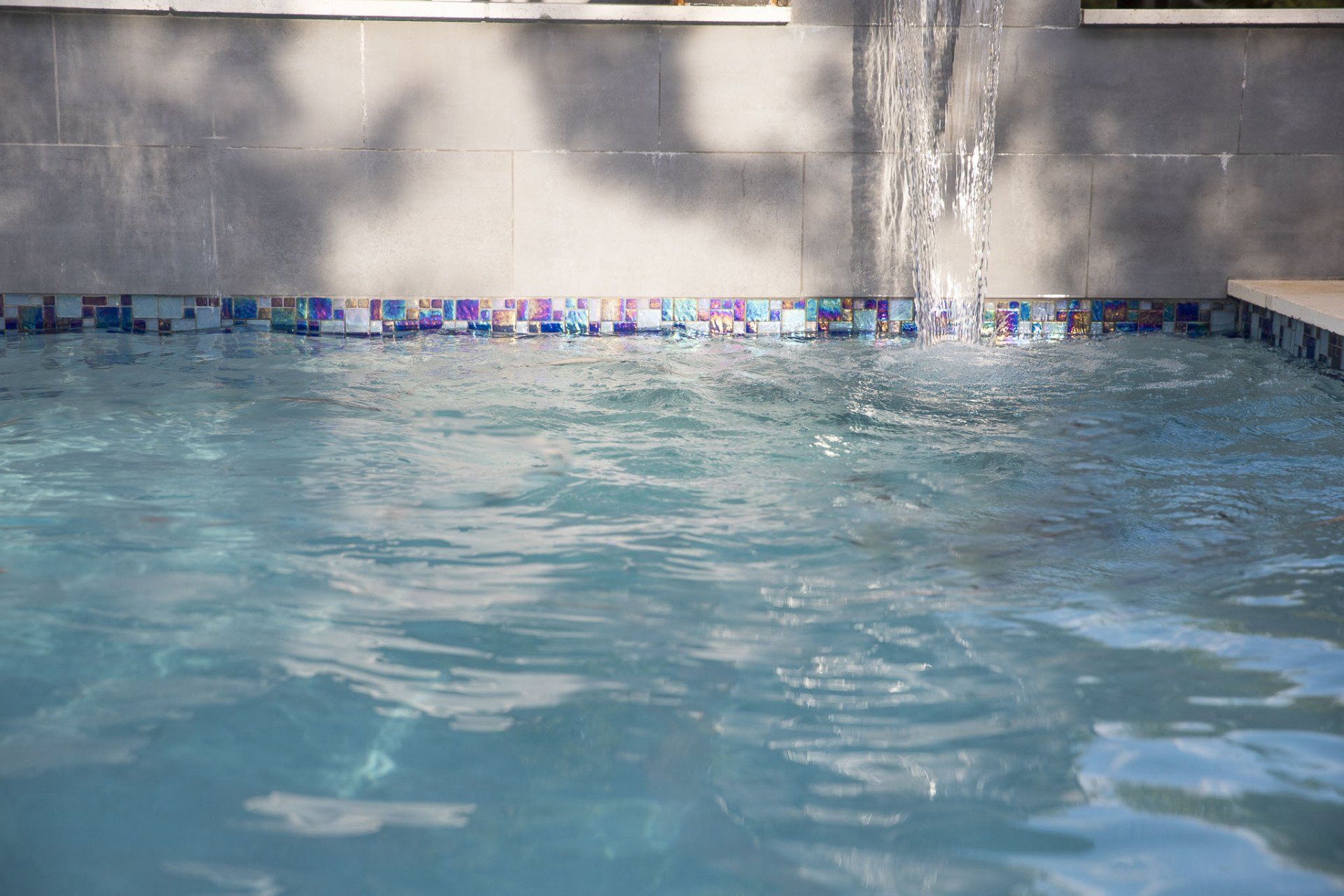 A swimming pool with a waterfall in the background.