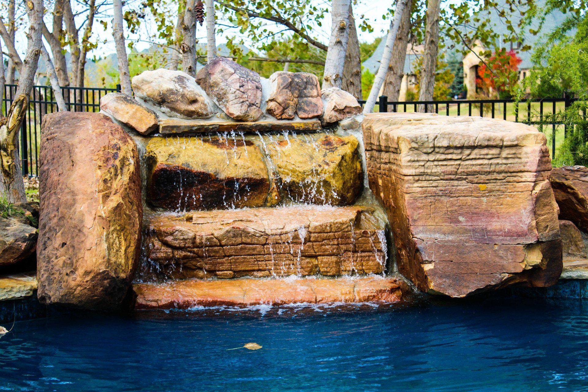 There is a waterfall in the middle of a pool surrounded by rocks.
