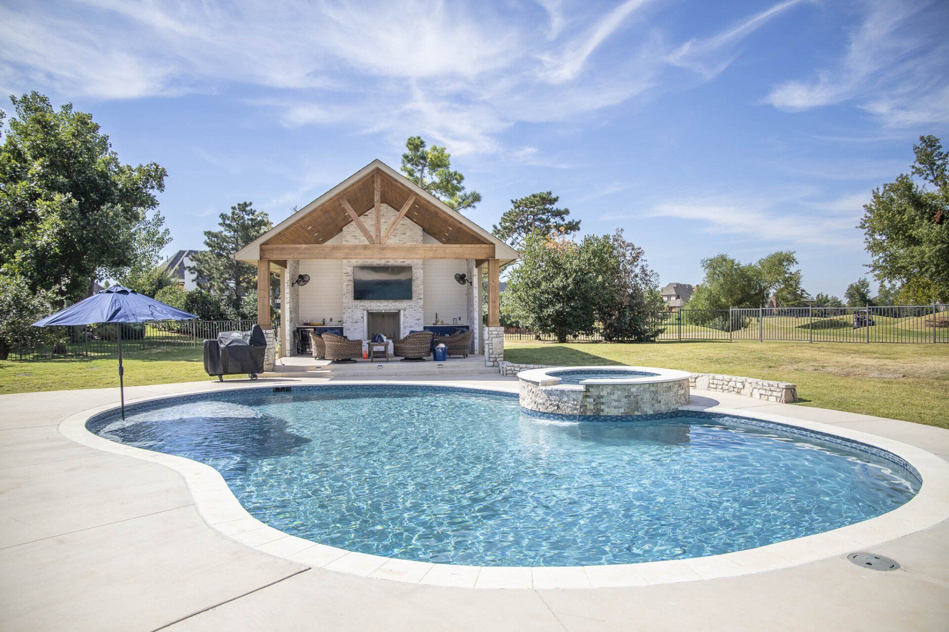 There is a large swimming pool in the backyard of a house.