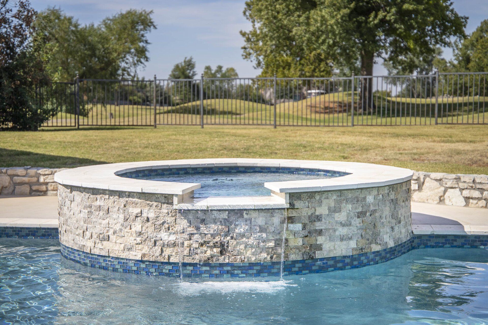 There is a hot tub in the middle of the pool.