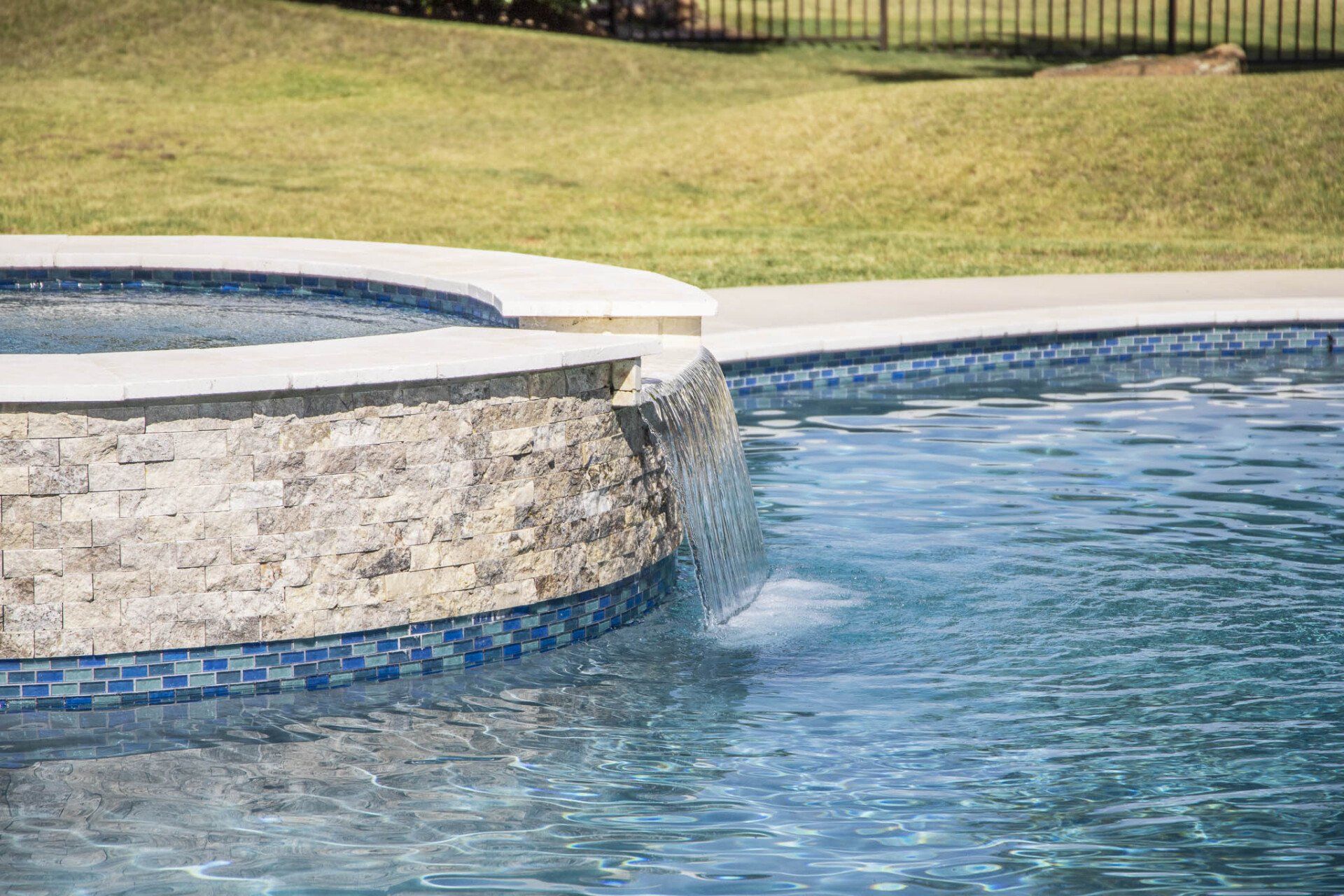 There is a waterfall in the middle of the pool.