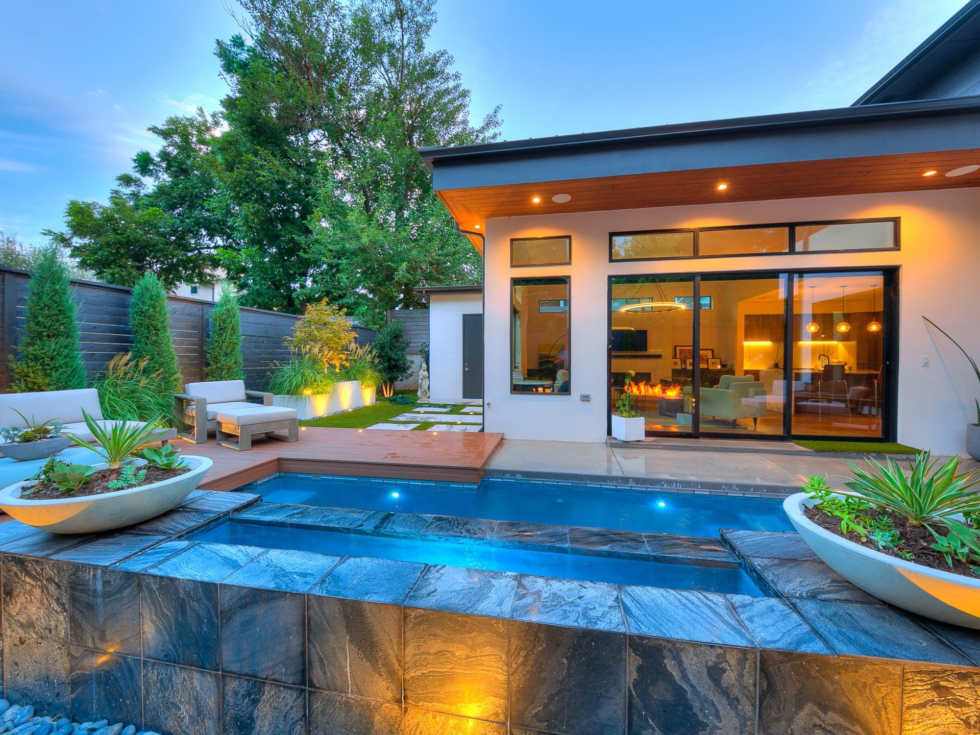 A house with a large swimming pool in front of it