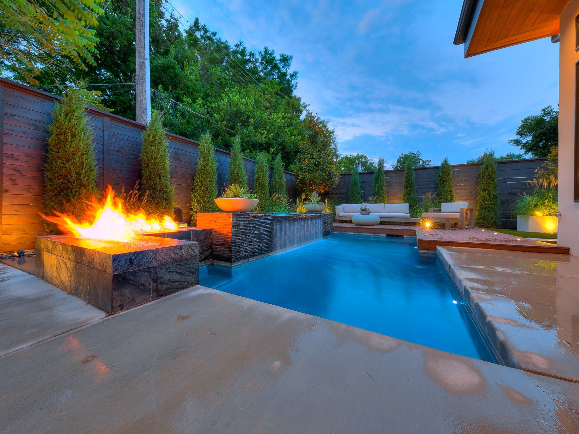 A large swimming pool with a fire pit in the middle of it