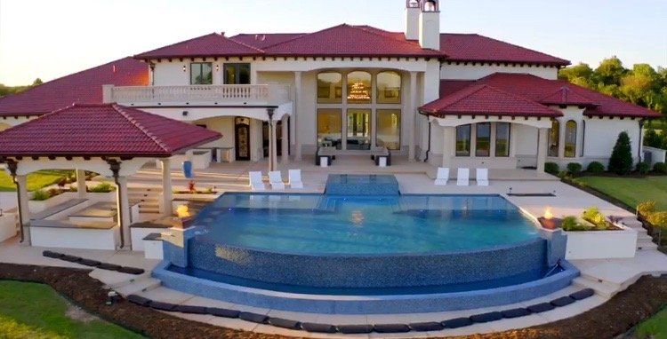 A large house with a swimming pool in front of it.