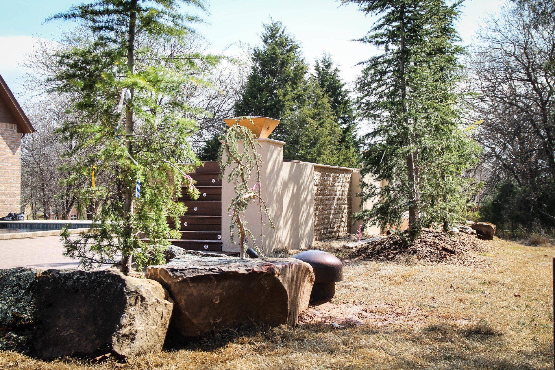 A large rock in the middle of a field with trees in the background