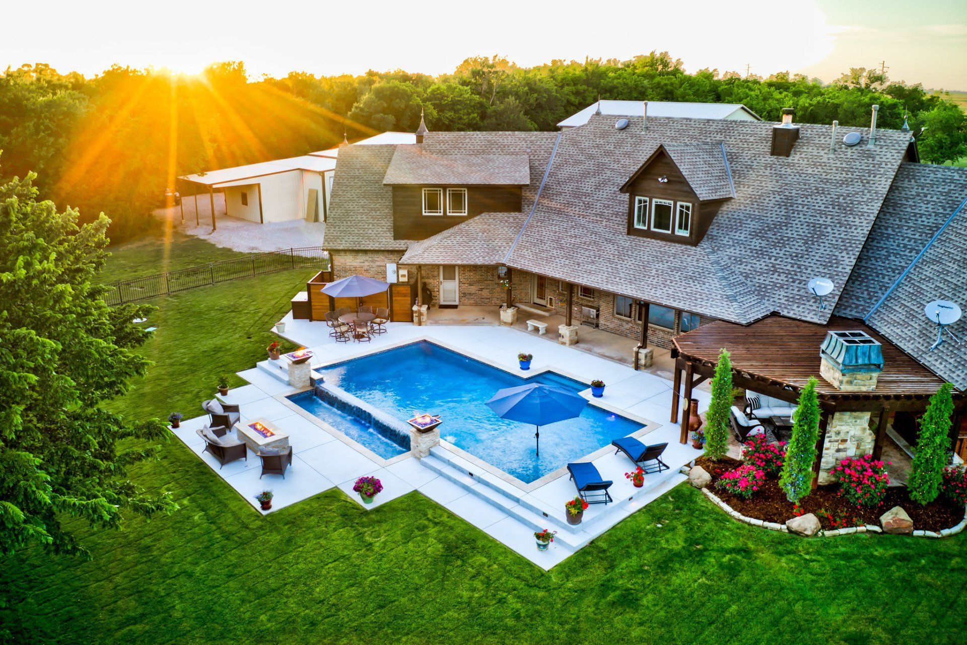 An aerial view of a large house with a large swimming pool in the backyard.