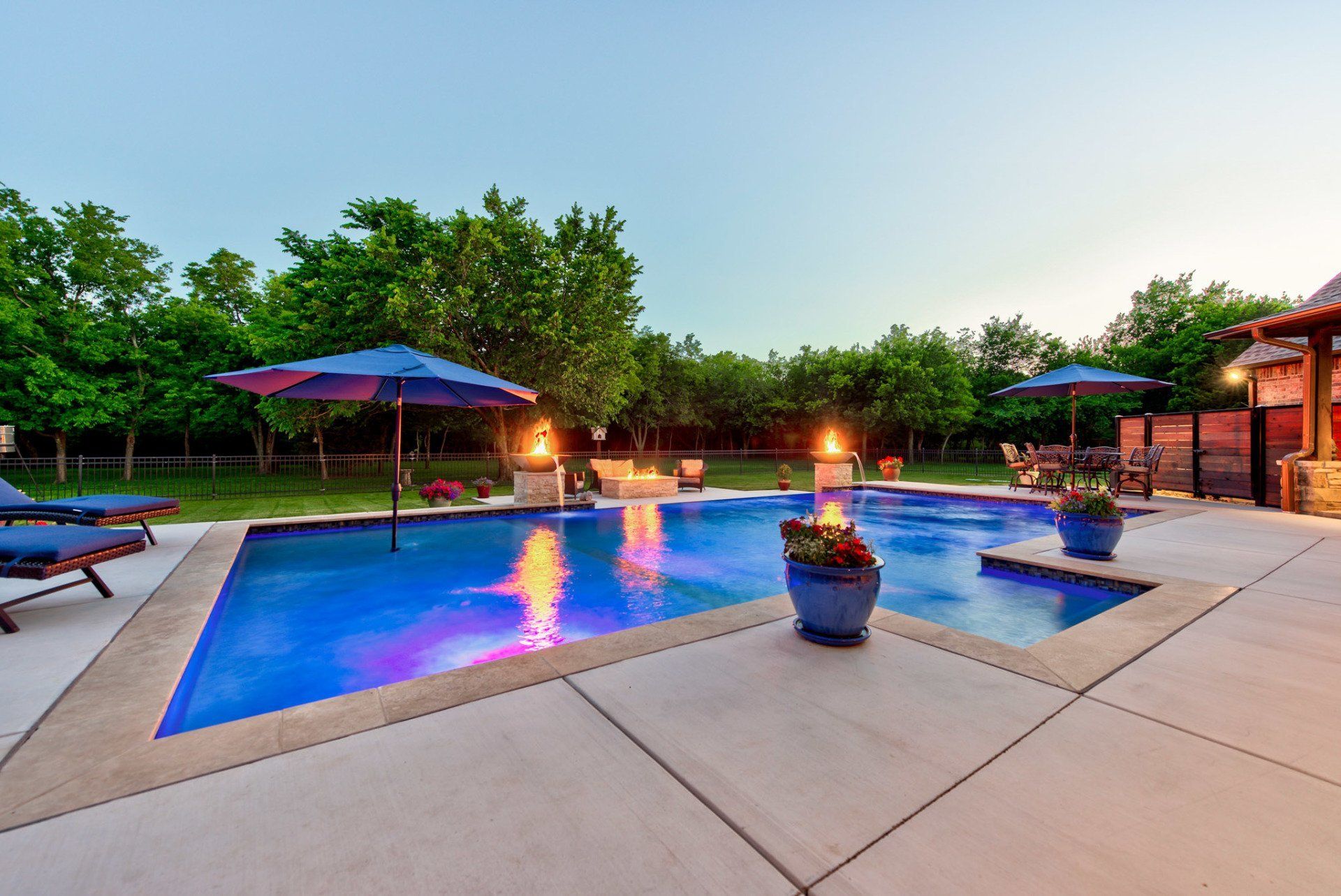 A large swimming pool with umbrellas and chairs around it
