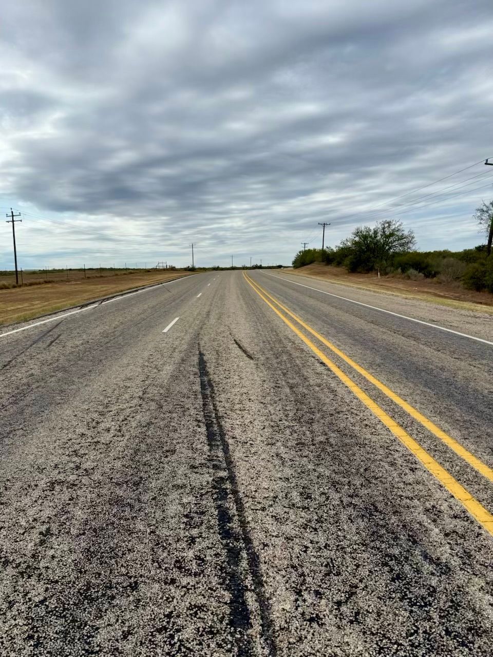 An empty road with a cloudy sky in the background