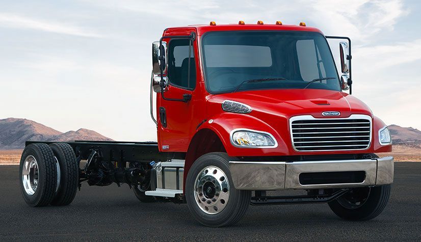 A red semi truck is parked on the side of the road
