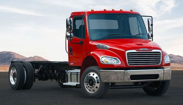 A red semi truck is parked on the side of the road