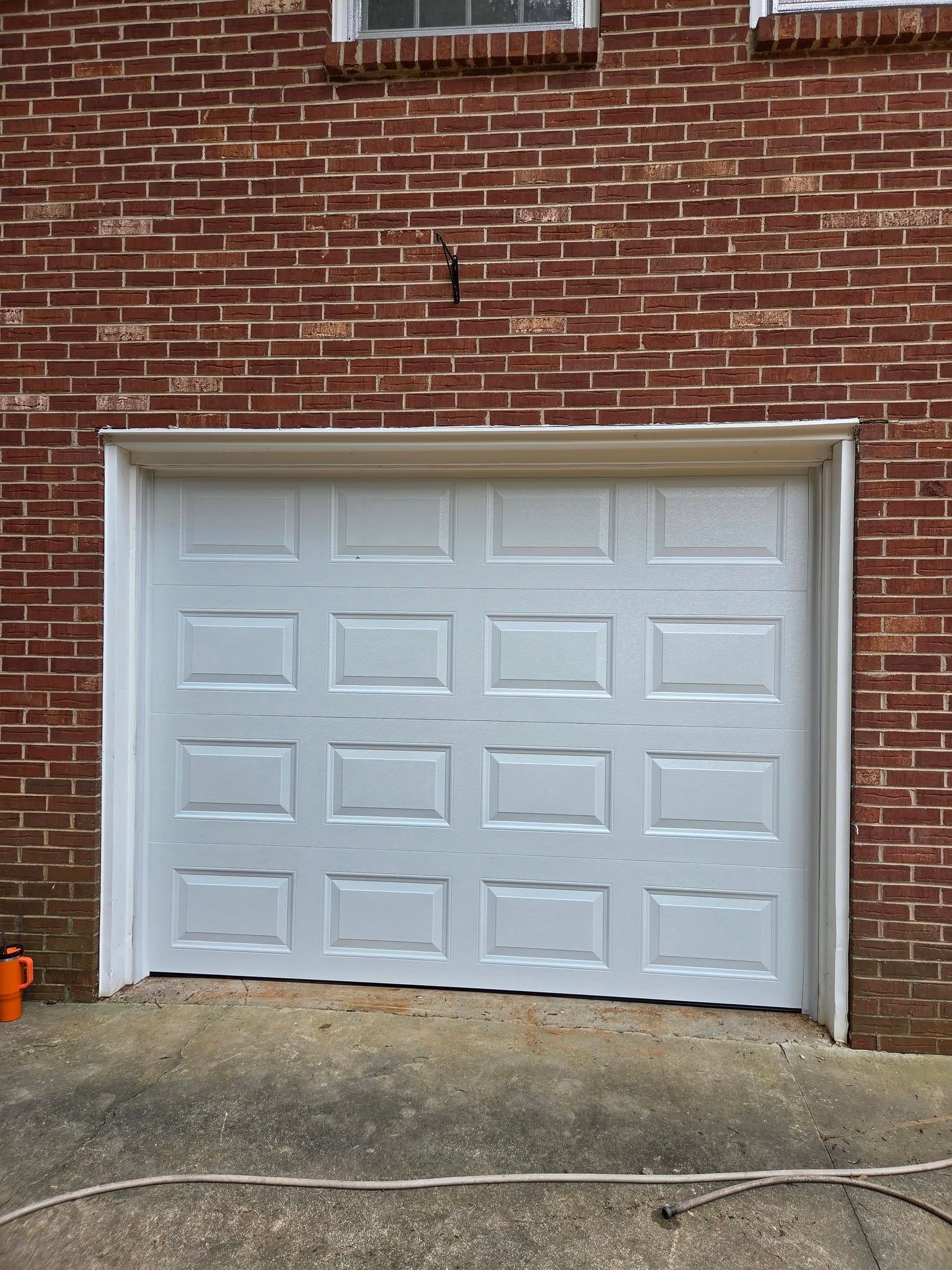 White garage door on a brick building.
