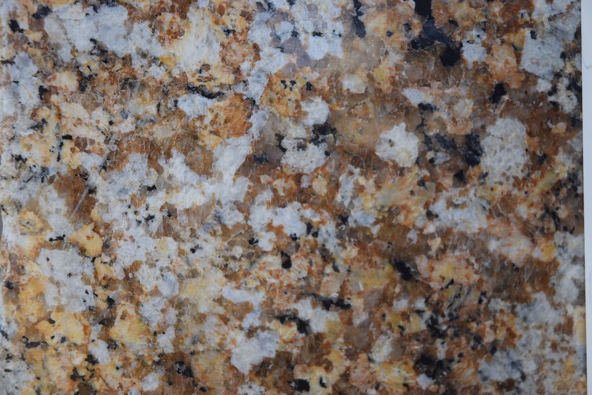 A close up of a brown and white granite counter top