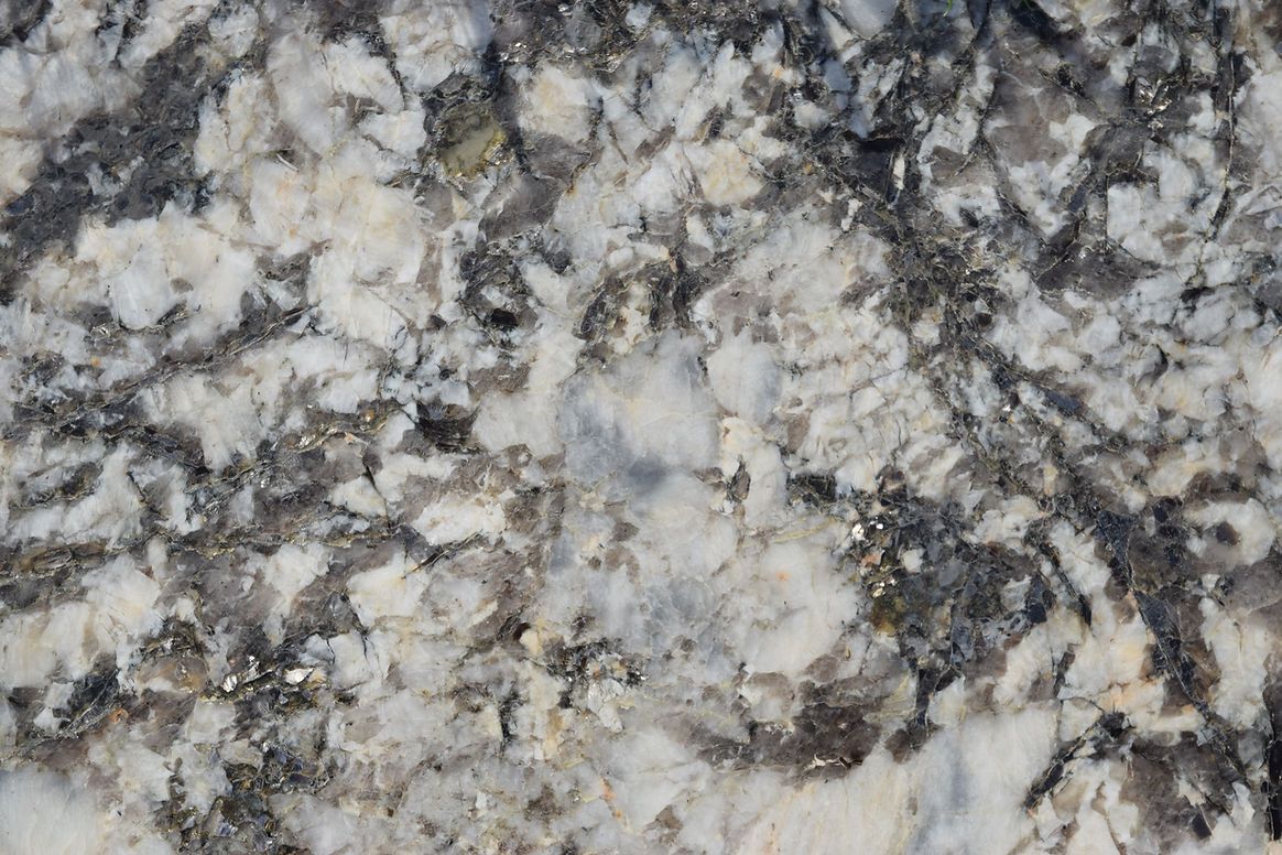 A close up of a granite counter top with a gray and white marble texture.