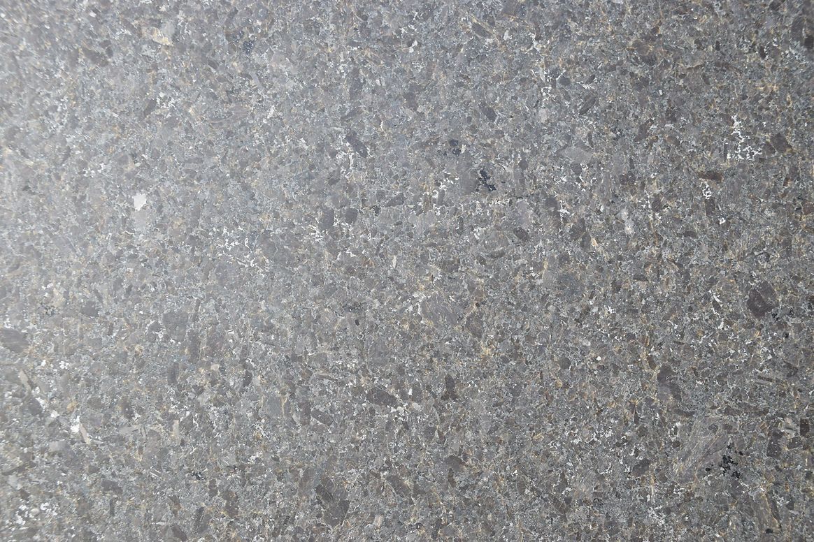 A close up of a gray surface with a lot of small stones on it.