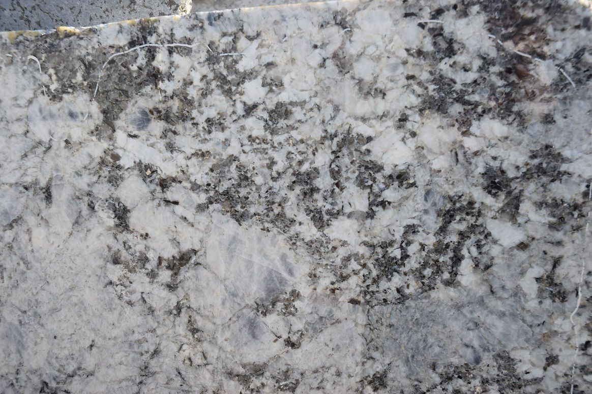 A close up of a piece of granite with a gray and white marble texture.