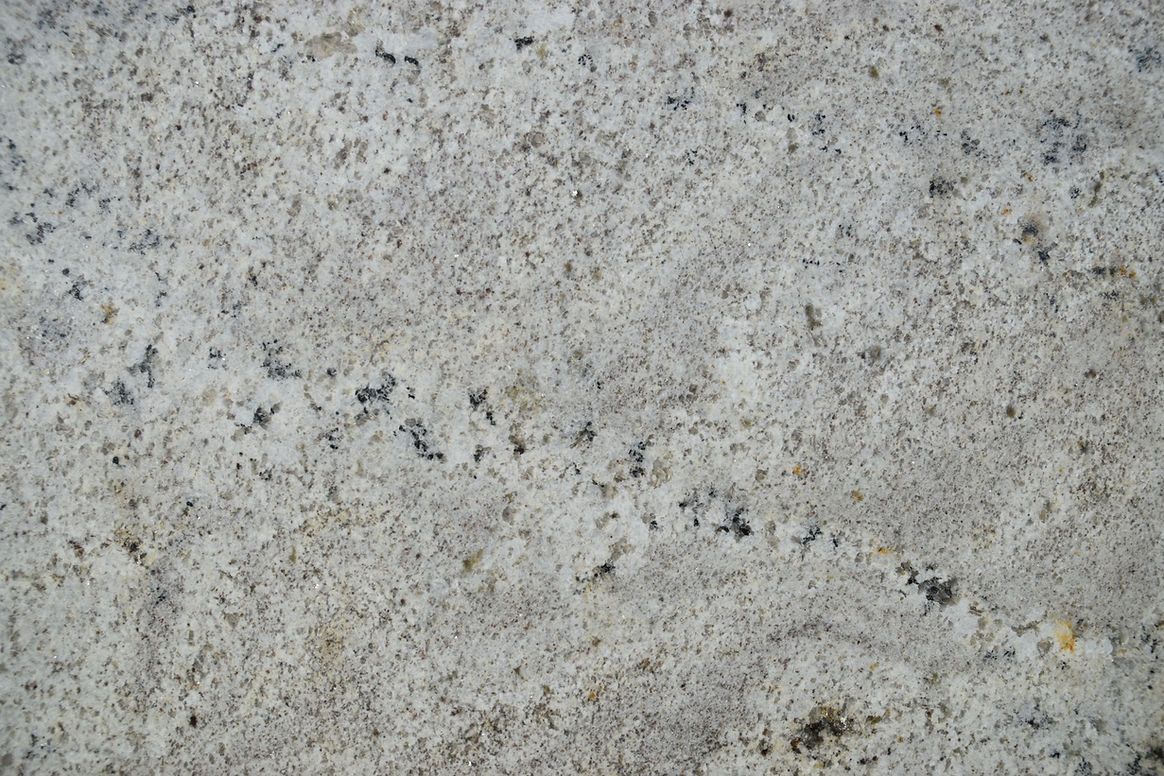 A close up of a white granite counter top.