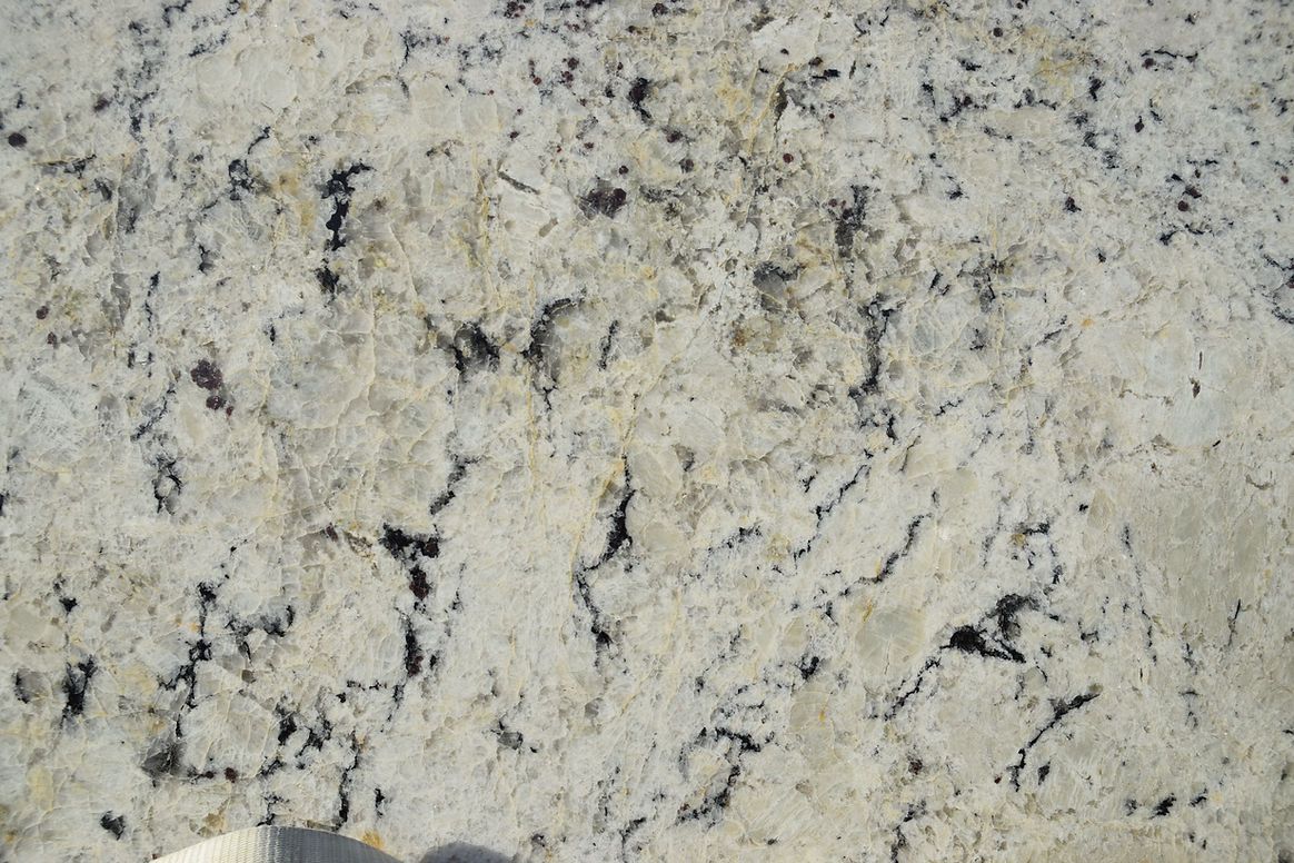 A close up of a white granite counter top with black spots
