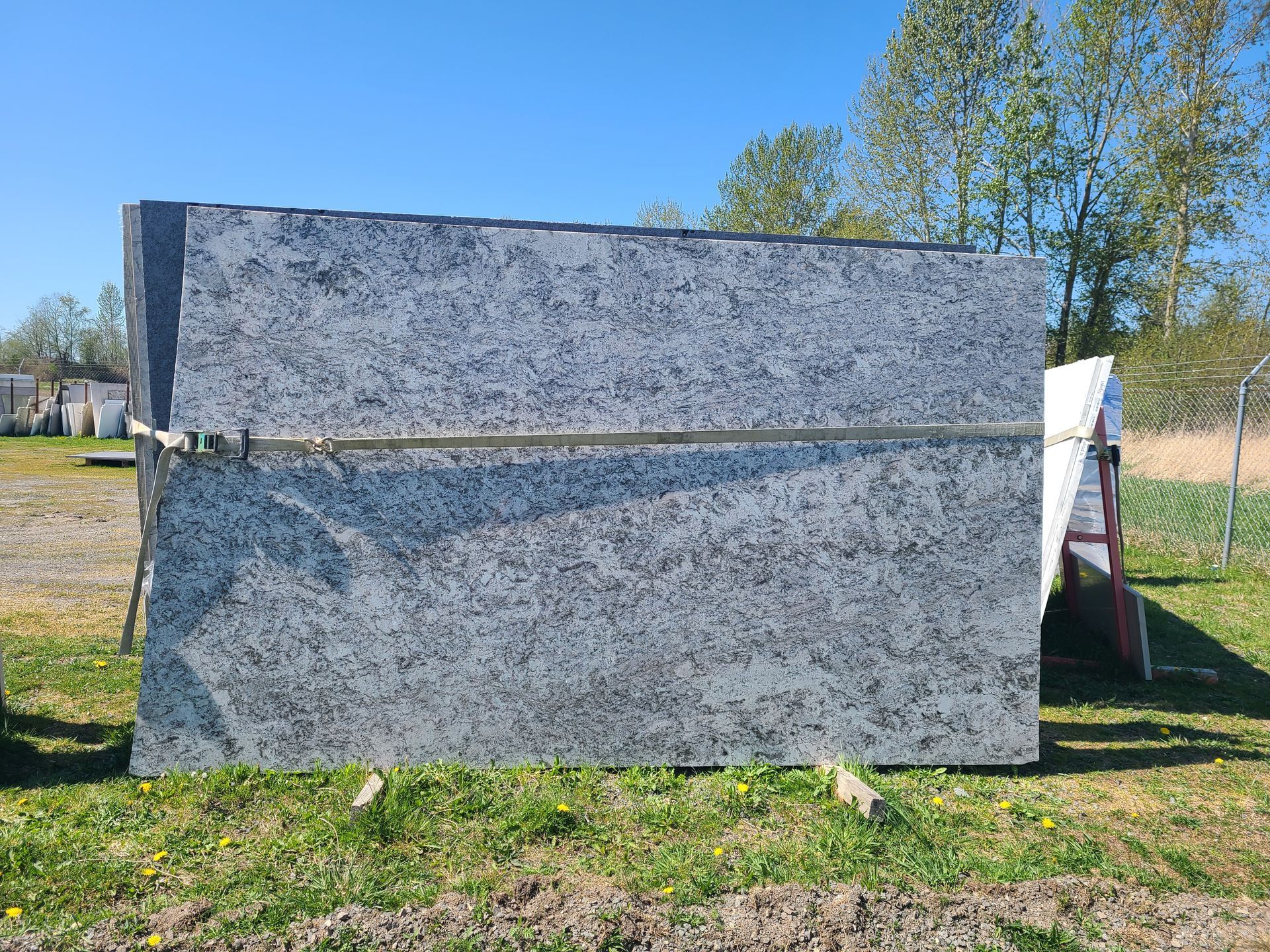 A stack of granite slabs sitting on top of each other in a grassy field.