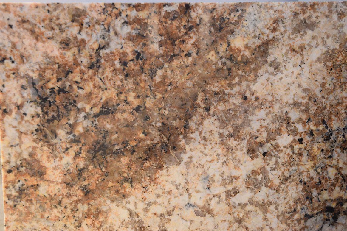 A close up of a piece of brown and white granite.