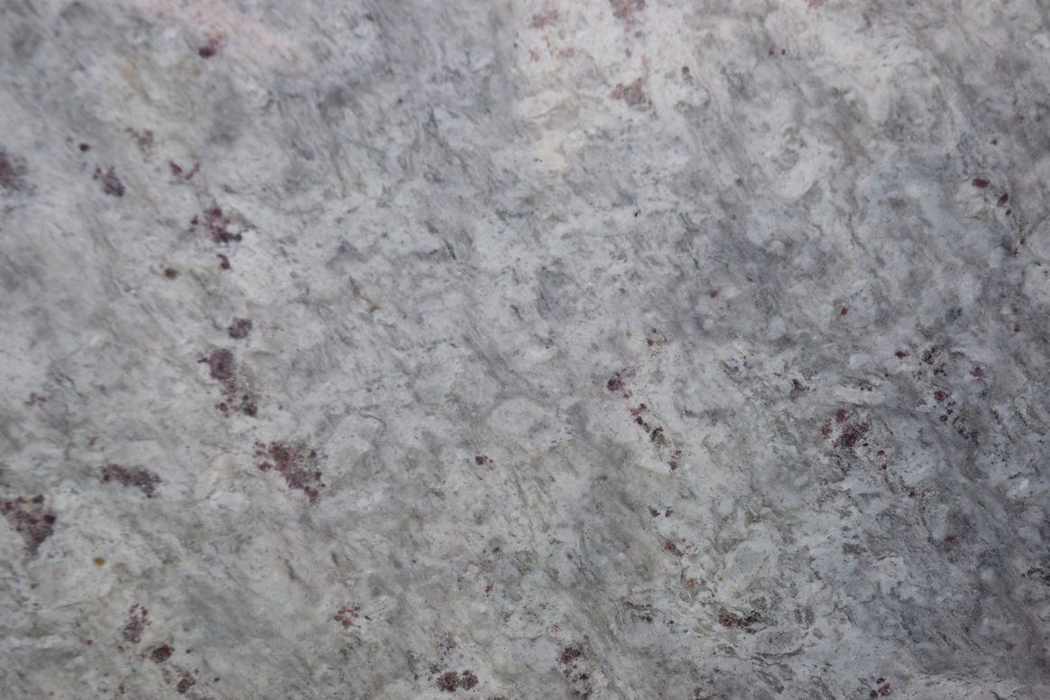 A close up of a white granite counter top.