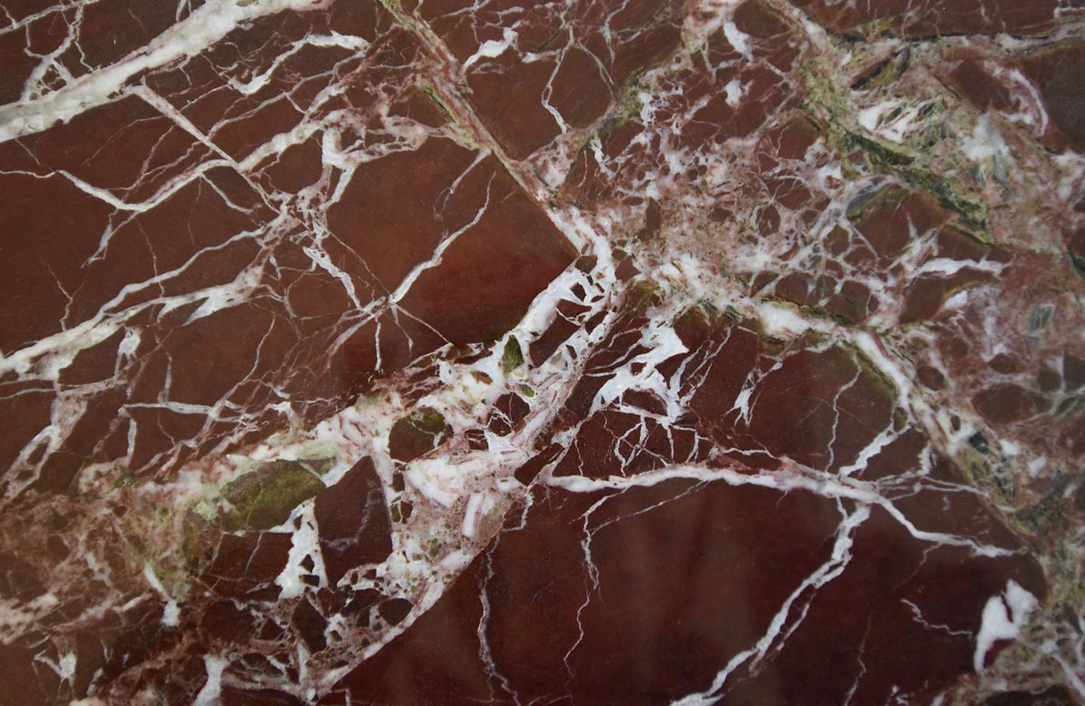 A close up of a brown marble surface with white veins