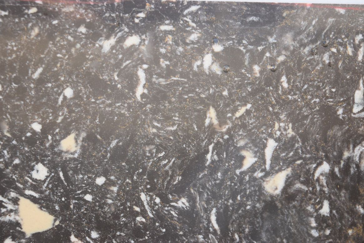 A close up of a black and white marble counter top.