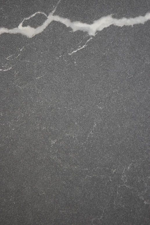 A close up of a black granite counter top with a white marble texture.